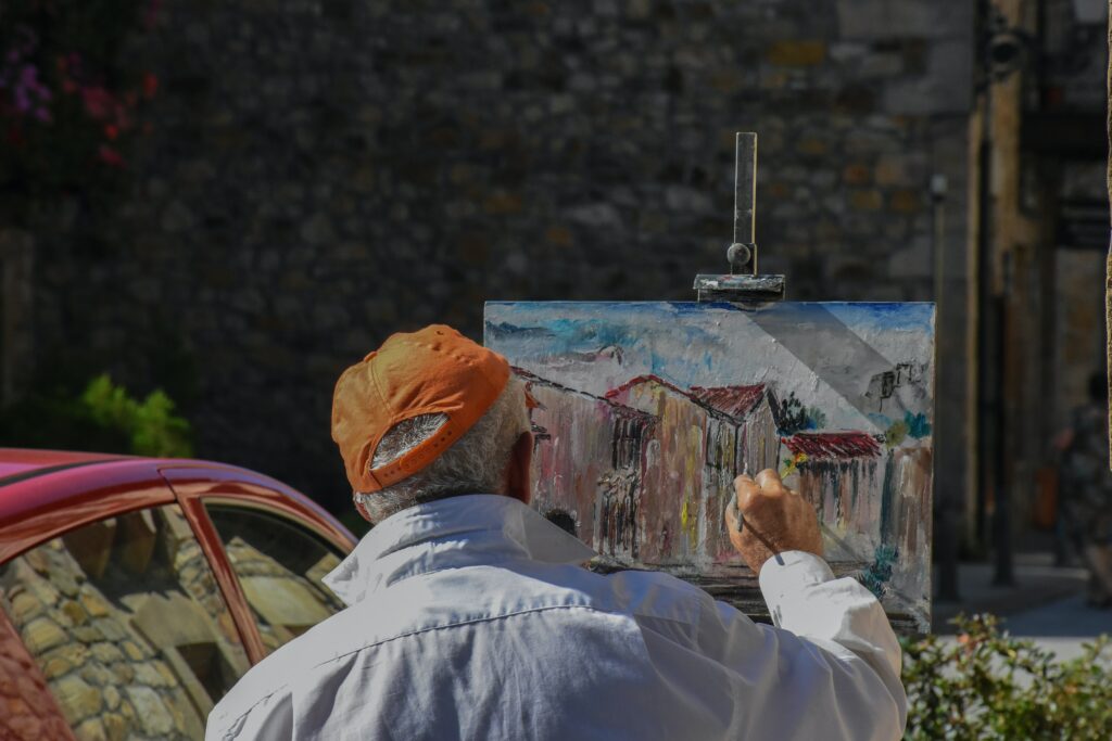 Old man painting a house